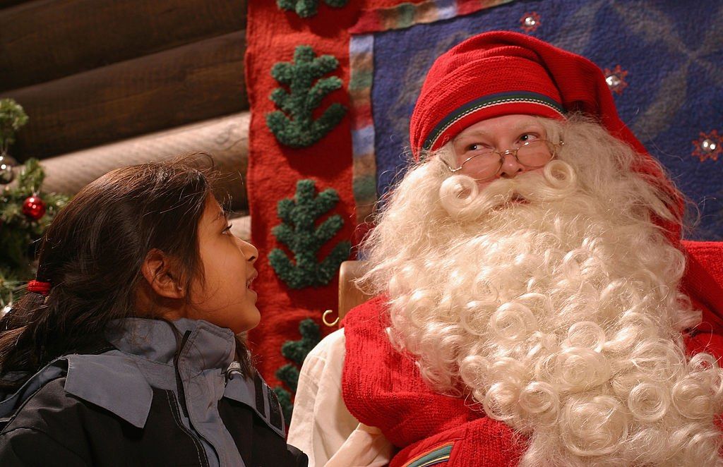 Kiasha Vekaria (6 years old) of Dartford, Kent, England, gazes at Santa Claus as she meets him in his office at Santa Claus village on the Arctic Circle near Rovaniemi, Finland on December 21, 2002.