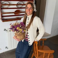 Mariana wearing a funnel-neck cardigan.