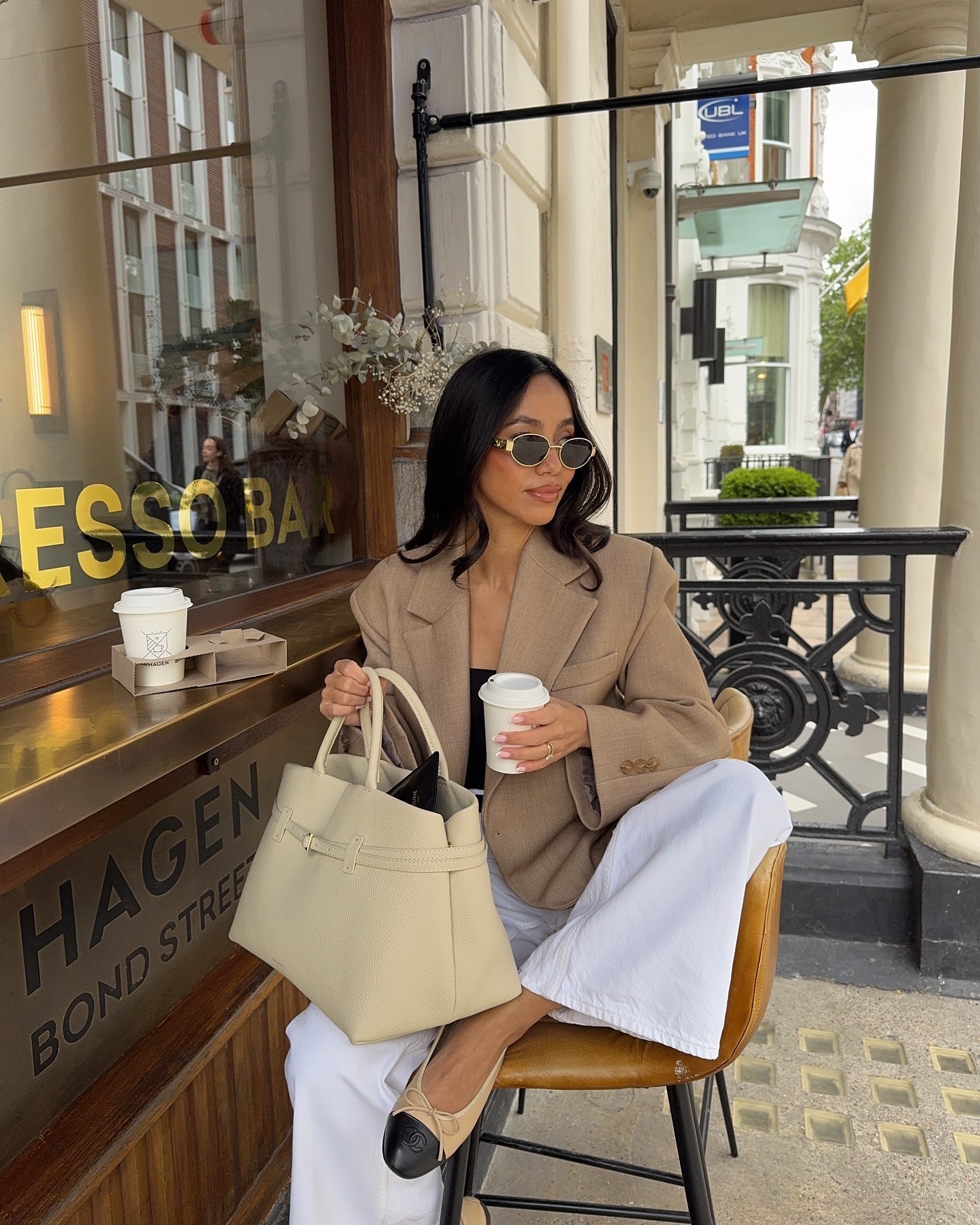 Fashion person Olivia Miller shows you hot to style white jeans. She pairs them with Chanel black and beige ballet flats a black top oversized brown blazer and butter yellow Manu Atelier bag in a recent image taken from her Instagram.