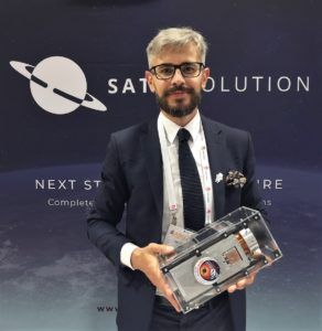 SatRevolution President Grzegorz Zwolinski holds a nanosatellite.