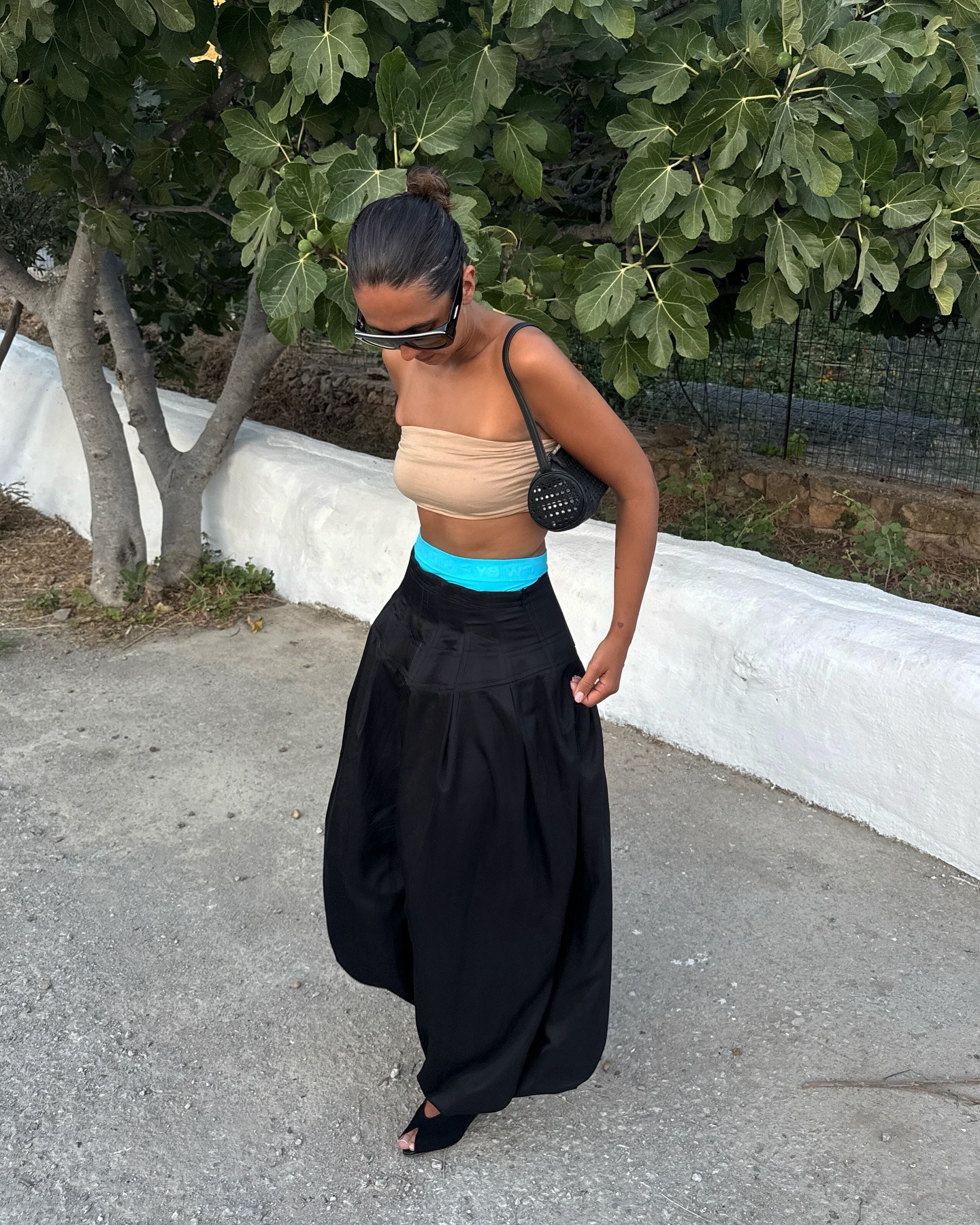 @hannamw wearing a tan strapless bra top with black genie pants.