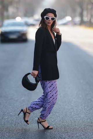 woman wearing a beret with a black blazer and purple patterned pants