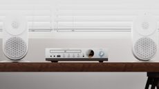 Lifestyle image of the Shanling CD80 II CD player between two white speakers on a wooden table or sideboard