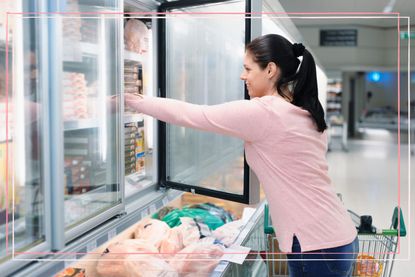Woman shopping for healthy frozen foods in supermarket