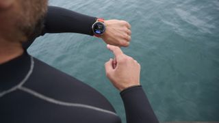 A man in a wetstuit looks at his Amazfit Balance 2 smartwatch