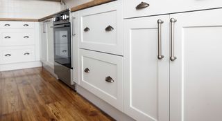 White kitchen base units with a mix of different handle types