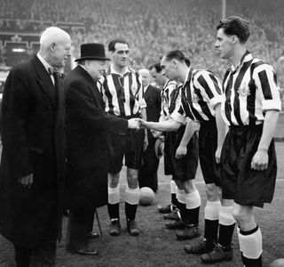 Winston Churchill is introduced to Jackie Milburn and the Newcastle team by captain Joe Harvey (PA)