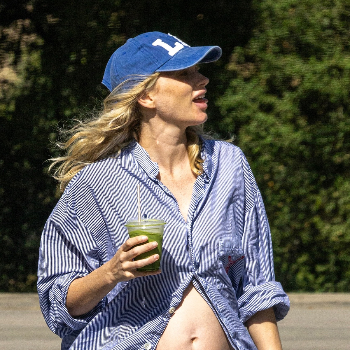 Elsa wears a baseball cap and a stripe button-down shirt.