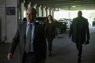 John Ortiz as Agent Quinones, walking through a parking structure in front of Tamsin Topolski as Lucie Snipes and Colman Domingo as Muncie Daniels, in Episode 102 of 'The Madness.'