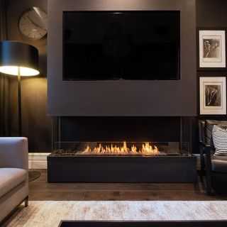 dark living room with soft lighting around a gas fireplace