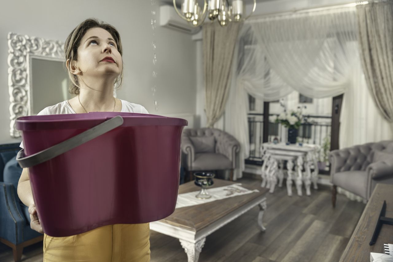 A woman with a bucket catching water