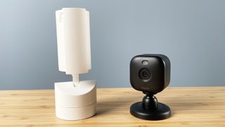 The Ring and Blink cameras stand side by side, the Ring camera has its privacy cover closed.