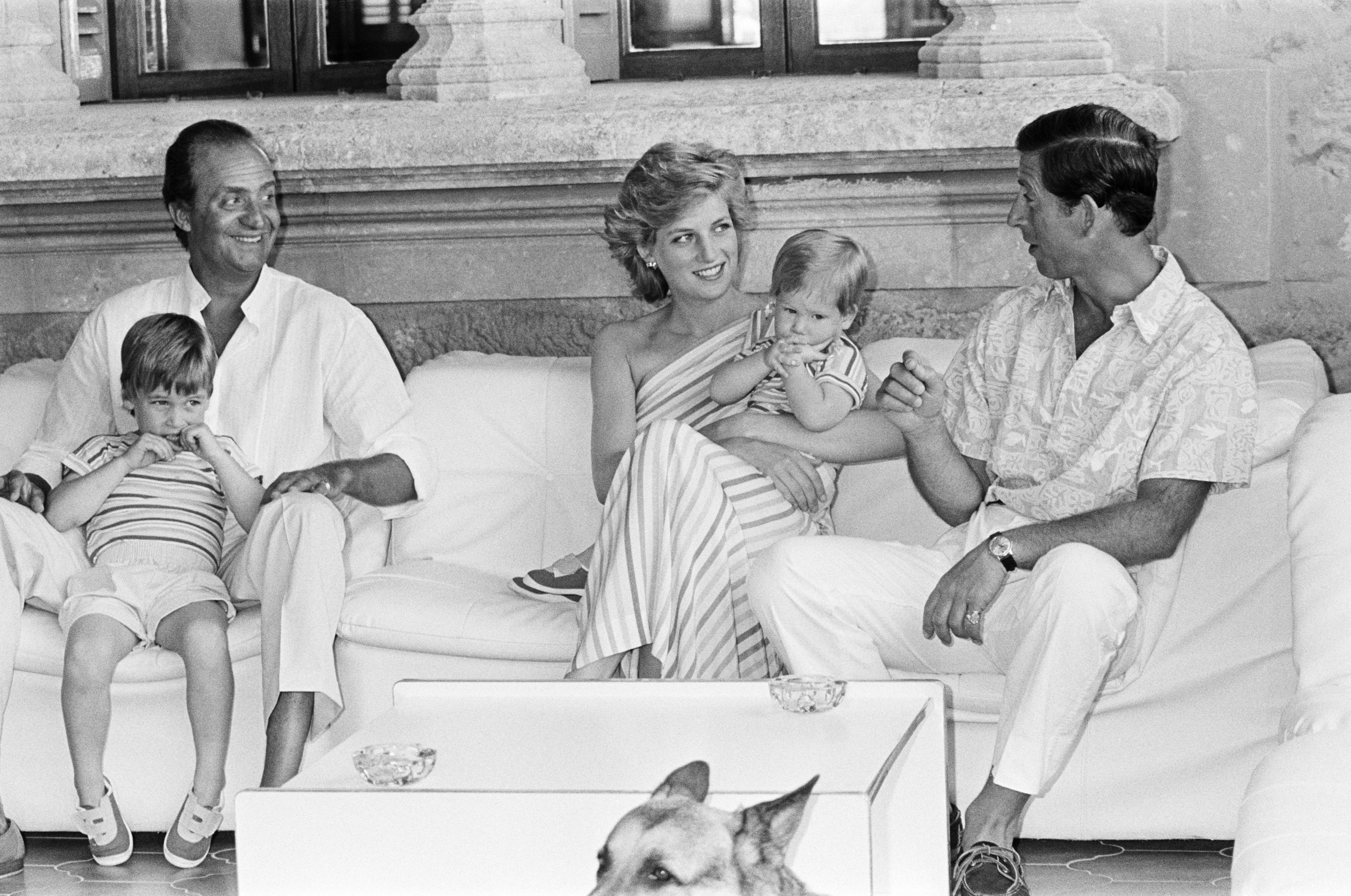 King Juan Carlos, Prince William, Prince Harry, Princess Diana and Prince Charles sitting on a sofa on vacation in Spain