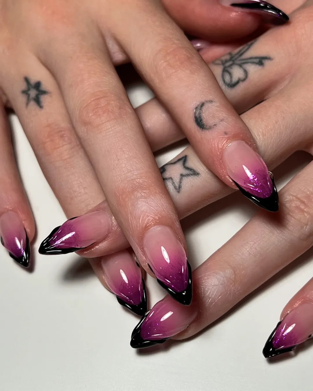 a black french manicure with purple airbrush designs