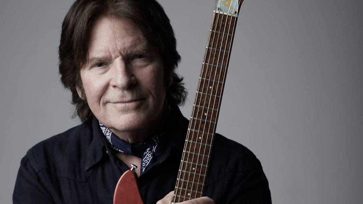 John Fogerty cradling a rickenbacker guitar