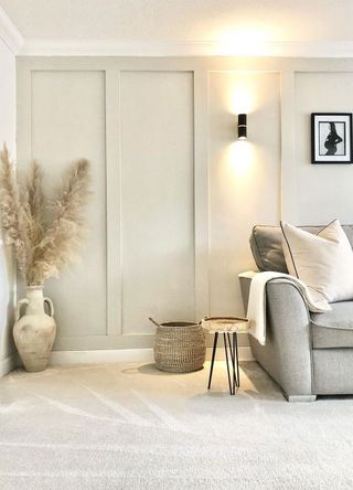 neutral living room with grey sofa and cream carpet and wall sconce