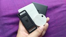 Various Google Find My Device Bluetooth trackers from Chipolo and Pebblebee held in one hand.