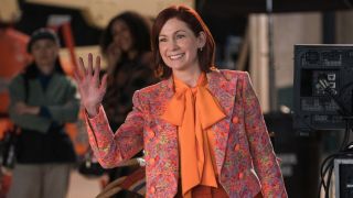 Carrie Preston as Elsbeth waving with her left hand.