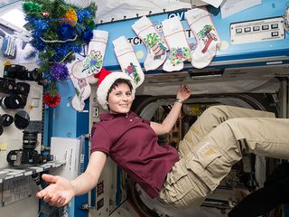 Italian astronaut Samantha Christoforetti floats with Christmas decorations, including stockings hung with care, on the International Space Station to celebrate Christmas in space in December 2014.