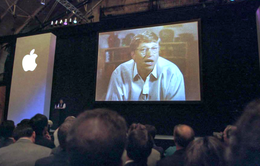 Microsoft Chairman Bill Gates addresses the Macworld Expo in Boston via phone link after Steve Jobs (small on stage) announced 06 August he will join the board of directors of Apple. Jobs also announced that Microsoft is investing 150,000,000 USD to purchase non-voting stock of Apple forging a new alliance between the two rival companies. AFP PHOTO John MOTTERN (Photo by JOHN MOTTERN / AFP via Getty Images)