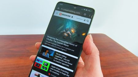 Hand holding a Poco M7 Pro phone with the Creative Bloq website on the screen