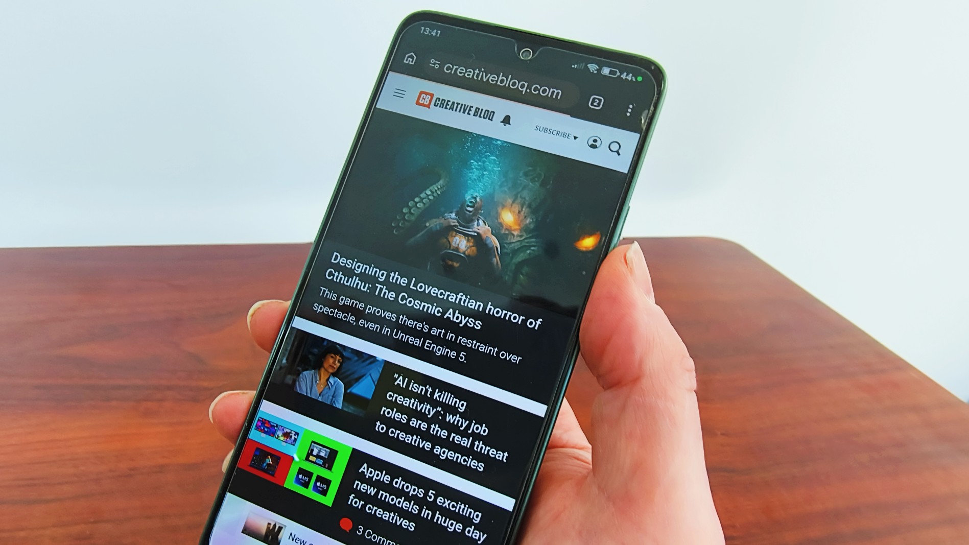 Hand holding a Poco M7 Pro phone with the Creative Bloq website on the screen