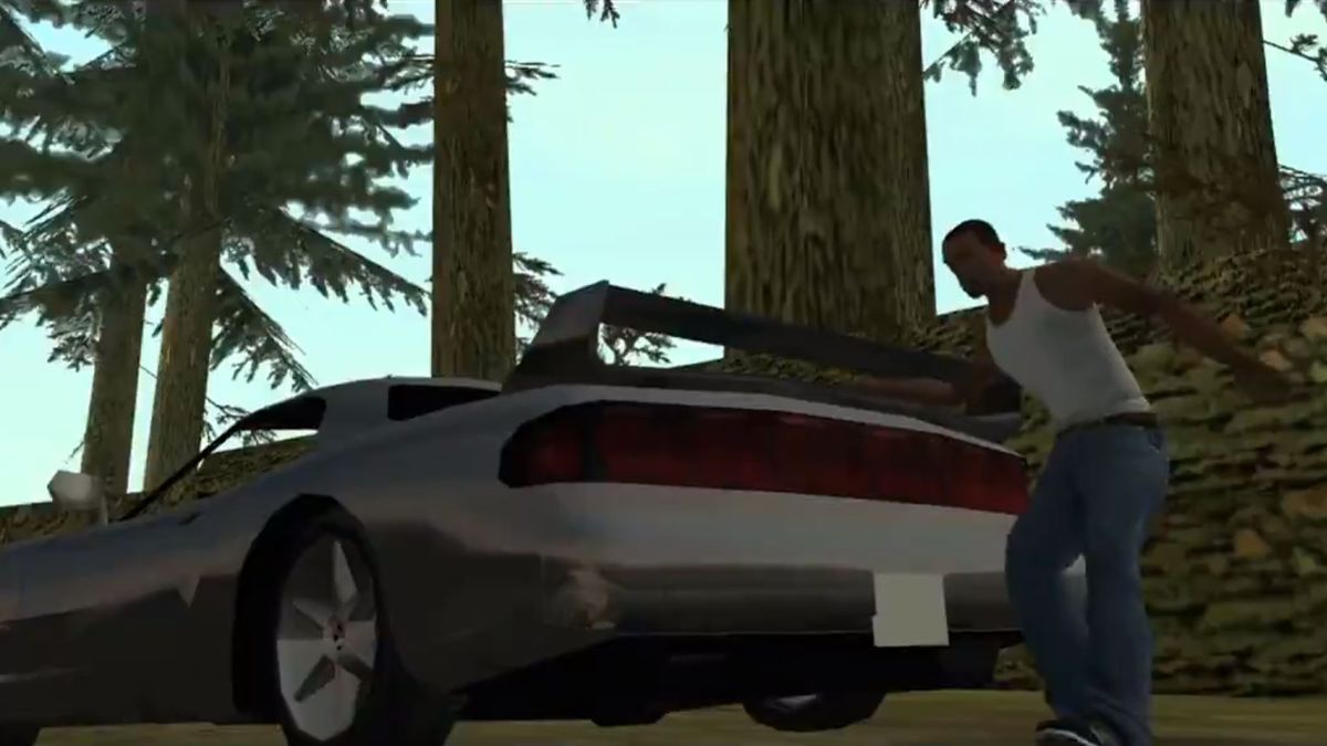 Man walking past the rear of a car in the woods