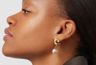 Woman with gaze away from camera wearing pearl sculptural earrings from Jenny Bird.