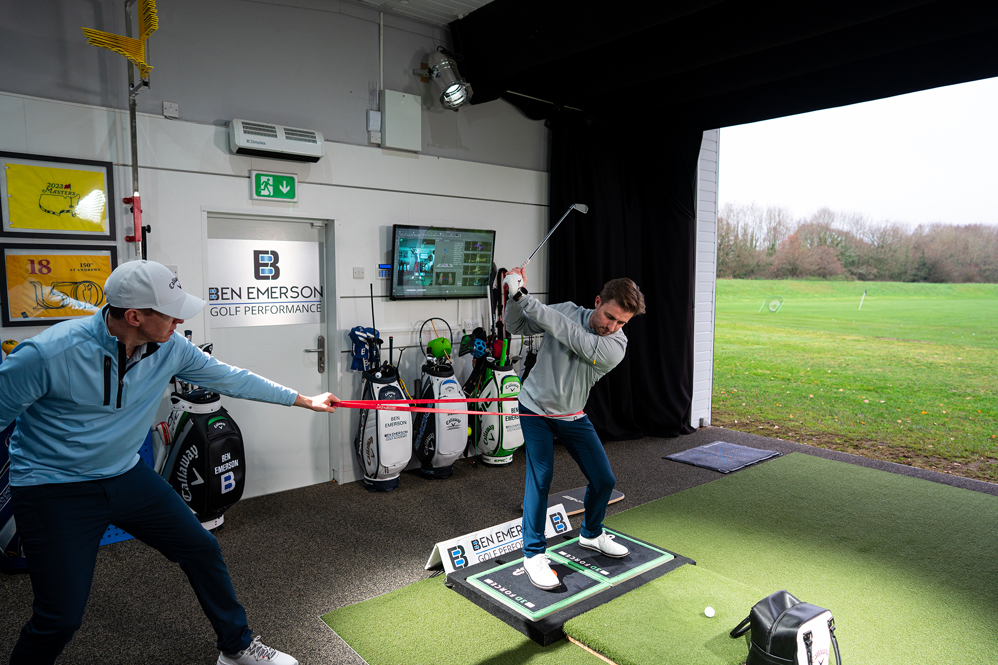 Ben Emerson using a tight band to prevent our reader Neil from swaying in the backswing during his golf lesson