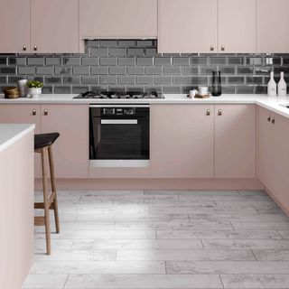 kitchen with pink coloured and black tiles on wall