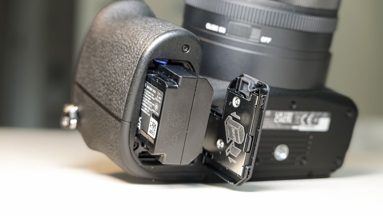 Closeup of the Sony RX10 V bridge camera's battery door, and the battery is half out