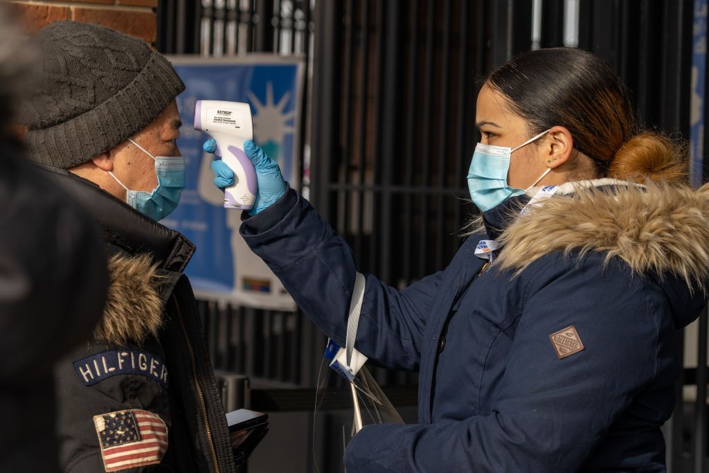 Person gets temperature checked before getting coronavirus vaccine.