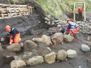 Archaeologists reveal the wall of a Viking longhouse.