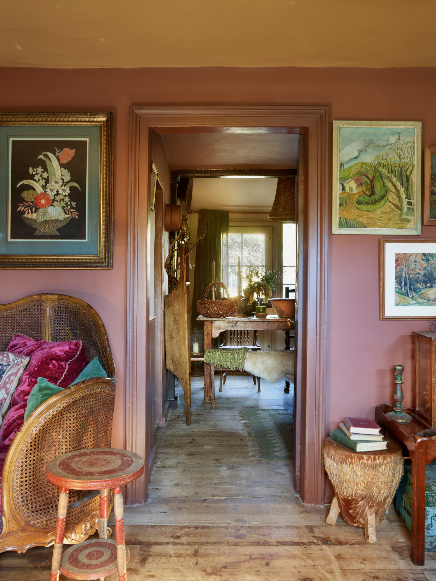 colorful hallway with timber floors, timber furniture, lots of artwork on the walls, and painted surfaces