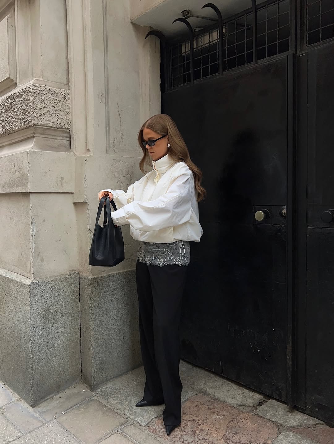 Influencer HANNA JOHANSSON wearing a cropped funnel-neck jacket, lace cami and black trousers.