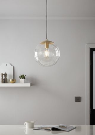 round glass pendant light above dining table, all white scheme