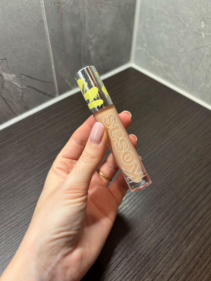 Deputy beauty editor Grace Lindsay holding a Kosas concealer