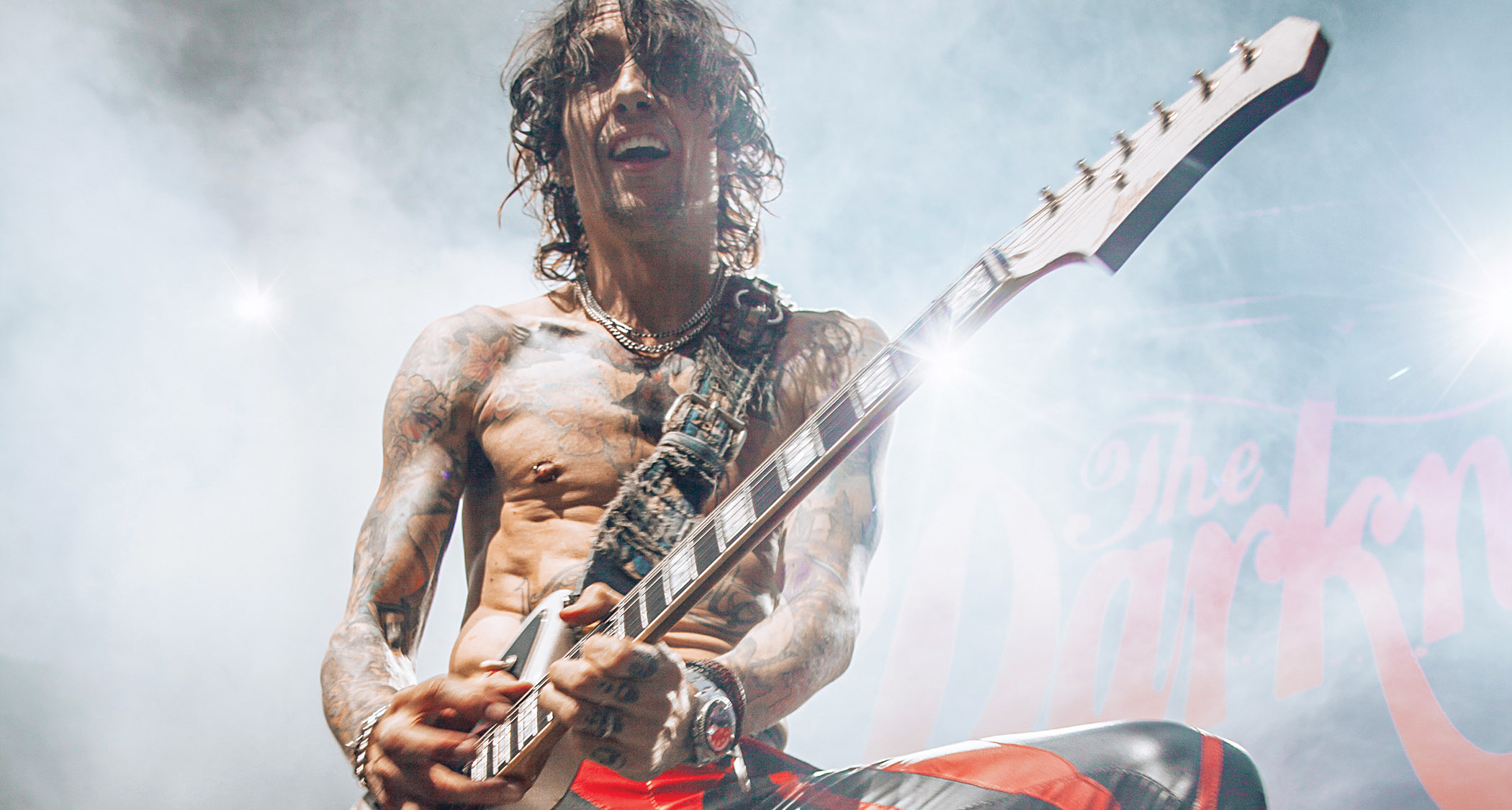 Justin Hawkins of the Darkness is shirtless onstage and rocking out.
