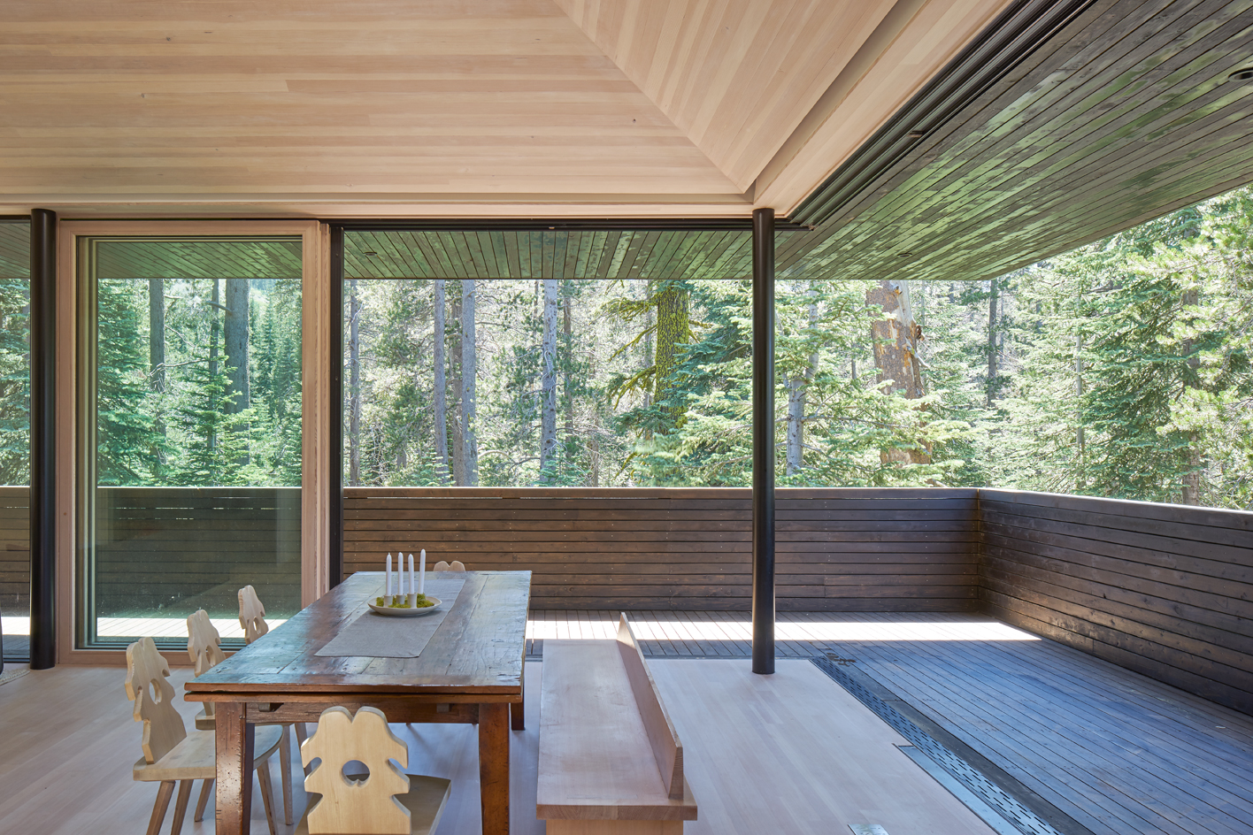 South-facing living area, sliding floor-to-ceiling windows open up on a sheltered terrace.