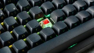 A photo of the Keychron Q3 Max on a stone surface showing the red linear switch underneath a keycap