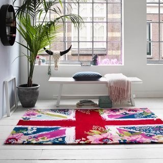 room with white wall and rug and potted plant