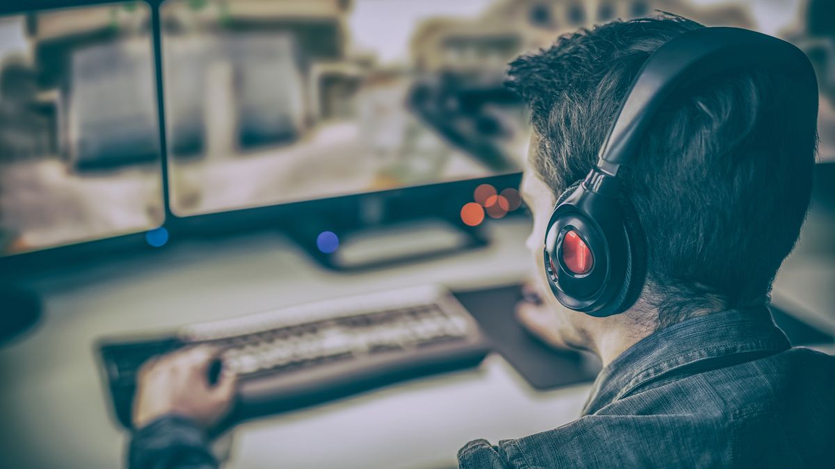 A PC Gamer sat in front of multiple monitors