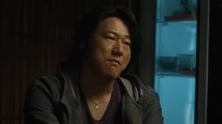 Sung Kang sits looking unimpressed in a flashback in F9.