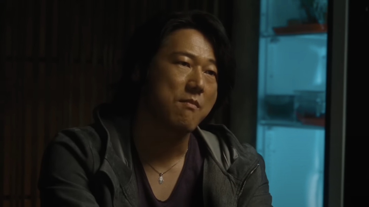 Sung Kang sits looking unimpressed in a flashback in F9.