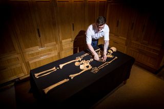 Historic Royal Palaces curator Alfred Hawkins inspects late medieval remains uncovered at the Tower of London.
