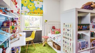 Colourful kid's bedroom with blue and yellow floral blinds, white metal bed and reclaimed radiator