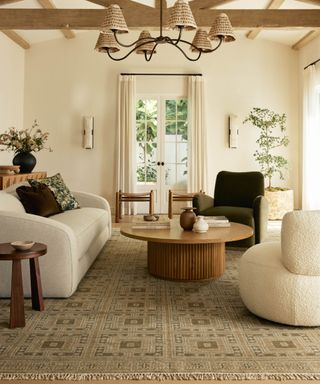 neutral living room by lulu and georgia with a large patterned rug and curved furniture