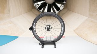 A front Roval Rapide CLX II wheel sits in front of the fan within a wind tunnel