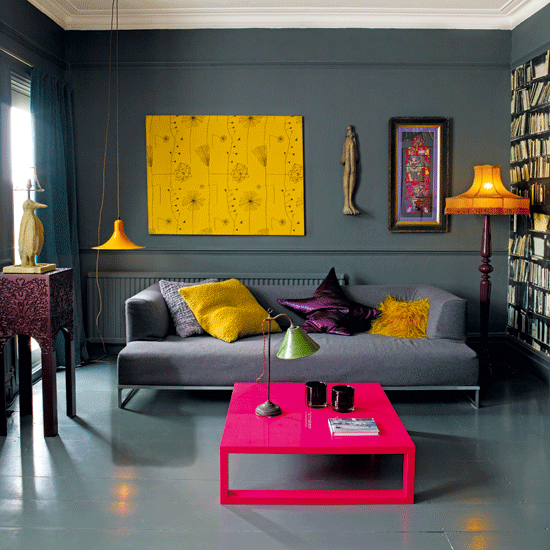 Modern living room with grey sofa, colorful pillows and pink coffee table