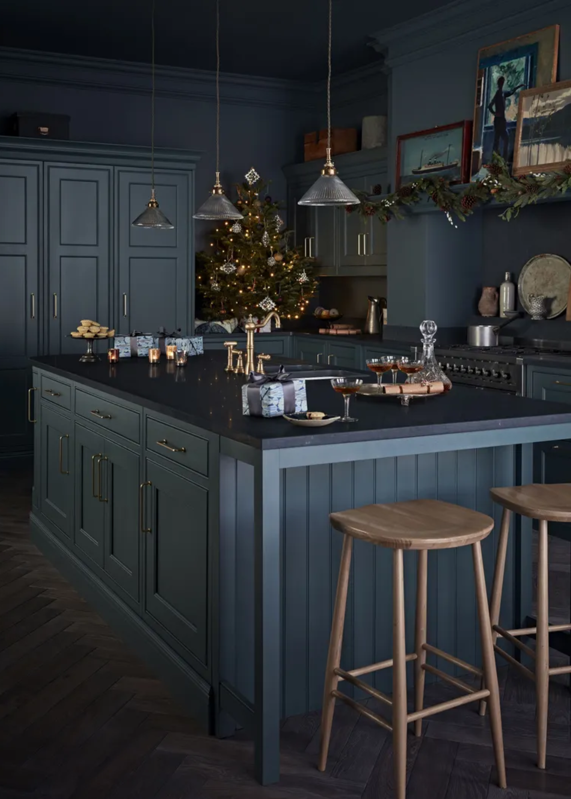 A dark blue kitchen with a color-drenched island and Christmas decor